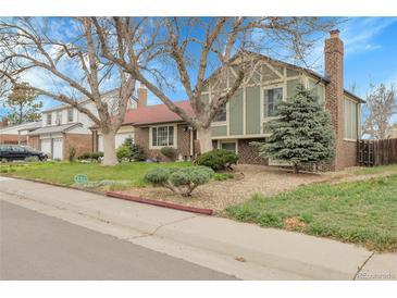 Charming home with mature trees, lush lawn, and well-maintained landscaping at 14867 E Harvard Ave, Aurora, CO 80014