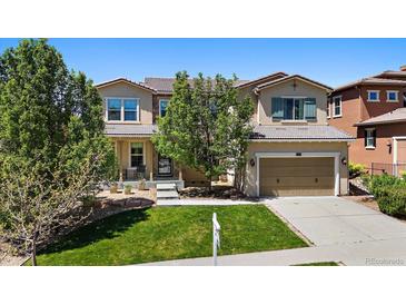 Charming two-story home featuring a well-manicured lawn, attached garage, and inviting front porch at 2263 S Loveland St, Lakewood, CO 80228