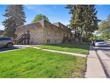 Two-story apartment building featuring well-maintained lawn and exterior stairs for upper units at 1390 Everett Ct # 105, Lakewood, CO 80215