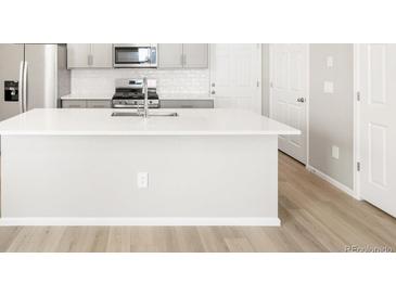 Bright kitchen featuring a large island with a sink and modern stainless steel appliances at 764 N Tempe St, Aurora, CO 80018