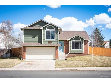 Charming two-story home boasts a well-maintained lawn, brick accents, attached two-car garage, and a light blue front door at 200 N Holcomb St, Castle Rock, CO 80104