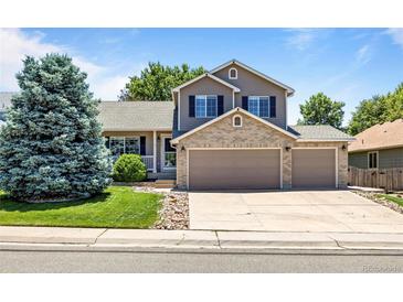 Charming two-story home with a brick facade and well-manicured lawn and an attached two car garage at 20858 E Progress Ave, Centennial, CO 80015
