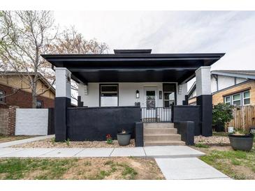 Charming home with a covered front porch, black and white painted brick, and a well-manicured front yard at 4267 Federal Blvd, Denver, CO 80211