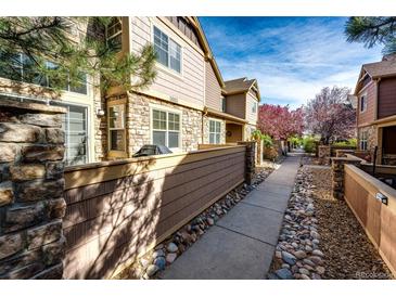 Charming townhome exterior featuring stone accents, wood siding, and a well-maintained walkway with landscaping at 5660 S Algonquian Way # C, Aurora, CO 80016