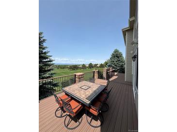 Outdoor deck featuring a dining table, chairs, and views of the golf course at 6323 S Sicily Way, Aurora, CO 80016