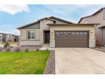 Charming single Gathering home featuring a two-car garage, stone accents, and manicured lawn at 23692 E 40Th Ave, Aurora, CO 80019