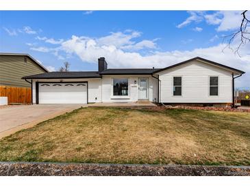 Charming single-story home featuring white siding, a black roof, and a well-manicured front yard at 16555 E Wesley Ave, Aurora, CO 80013