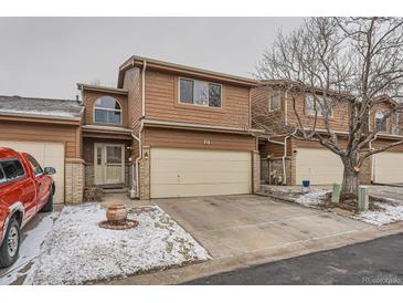 Two story home with tan wood facade, two car garage, and decorative arched window at 45 Wright Ct, Lakewood, CO 80228