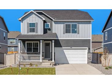 Two-story home with gray siding, covered porch, stone accents, and an attached two-car garage at 18328 Prince Hill Cir, Parker, CO 80134