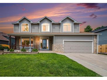 Charming two-story home featuring stone accents, three dormer windows, and a well-manicured lawn at 5573 S Taft St, Littleton, CO 80127