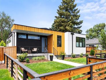 Contemporary home featuring wood and black siding, a well-manicured lawn and modern landscaping, and a lovely entryway at 2025 Fenton St, Edgewater, CO 80214