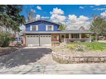 Charming two-story home boasts a blue exterior, brick accents, and a convenient two-car garage at 12821 W 60Th Ave, Arvada, CO 80004