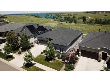 Scenic aerial view of modern homes with solar panels and a serene lake backdrop on a sunny day at 26741 E Peakview Pl, Aurora, CO 80016