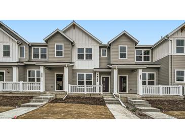 Charming townhomes featuring a modern farmhouse design and inviting front porches at 700 N Bently St, Watkins, CO 80137