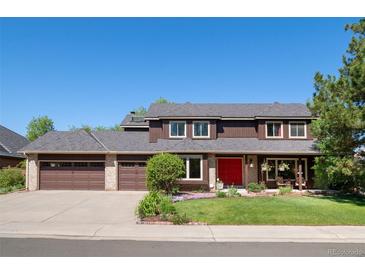 Charming two-story home with a red front door, a three-car garage, and a well-maintained lawn at 5753 S Kittredge St, Centennial, CO 80015