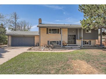 This home boasts a charming brick facade, gray accents, and a well-manicured lawn at 13086 E Alaska Ave, Aurora, CO 80012