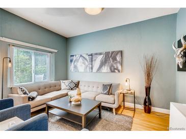 Inviting living room featuring a large sectional sofa and stylish decor against a blue accent wall at 3736 N Mariposa St, Denver, CO 80211