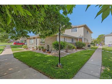Well-maintained exterior with a green lawn, mature trees, and tidy landscape beds at 9255 E Lehigh Ave # 194, Denver, CO 80237