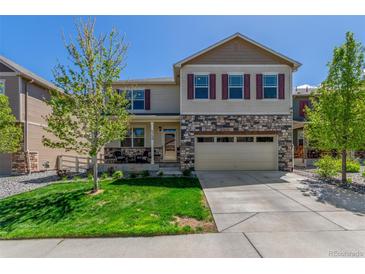 Charming two-story home featuring stone accents, a well-manicured lawn, and a convenient two-car garage at 5758 Echo Park Cir, Castle Rock, CO 80104