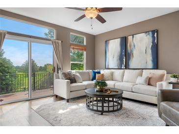Bright living room with large windows, patio access and comfortable furnishings at 8922 S Tuscany Ln, Highlands Ranch, CO 80130