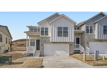 Charming modern farmhouse featuring stone accents, bright white siding, and a two-car garage at 1785 Grayside Cir, Castle Rock, CO 80109