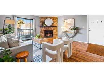 Inviting living room with a stone fireplace, wood floors, and bright natural light at 8600 E Alameda Ave # 13-108, Denver, CO 80247