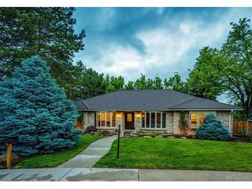 Charming single-story brick home with a beautifully landscaped front yard and inviting walkway to the front door at 10601 E Crestline Ave, Englewood, CO 80111