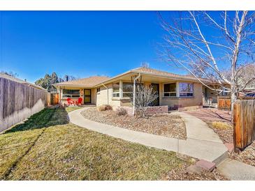 Charming single-story home with manicured lawn, walkway, and mature landscaping at 3209 N Olive St, Denver, CO 80207