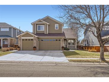 Inviting two-story home featuring a three car garage, brick accents and well maintained lawn at 3080 Madison Ln, Broomfield, CO 80023