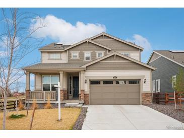 Charming two-story home showcasing a well-maintained front yard and a welcoming covered porch at 1884 Myron Ct, Erie, CO 80516