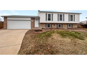 Charming two-story home featuring a brick and white siding, attached garage, and well-manicured front yard at 10930 Albion Ct, Thornton, CO 80233