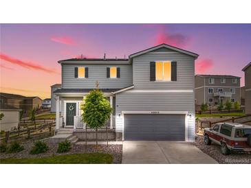 Charming two-story home with a gray exterior, well-manicured lawn, and attached two-car garage at 42853 Ivydel St, Elizabeth, CO 80107