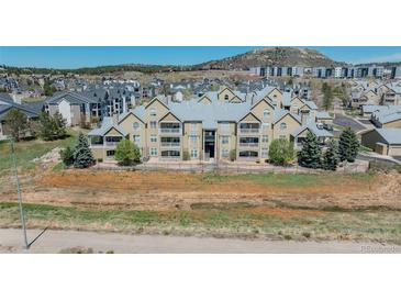 Exterior of condominiums with multiple levels, balconies, and landscaping on a sunny day at 6017 Castlegate Dr # F15, Castle Rock, CO 80108