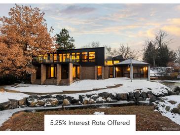 A modern two-story home with large windows and a well-kept landscape covered with snow at 7177 W 8Th Ave, Lakewood, CO 80214