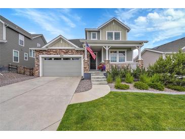 Charming two-story home with a covered porch, a stone facade, landscaped yard and an attached two-car garage at 8839 Culebra St, Arvada, CO 80007