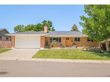 Charming single-story brick home with a well-manicured lawn and an attached two-car garage at 3025 S Norman Ct, Denver, CO 80224