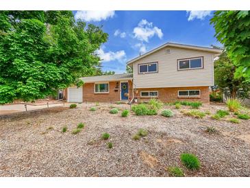 Charming brick and siding home with a blue front door and neatly landscaped yard at 962 S Potomac Way, Aurora, CO 80012