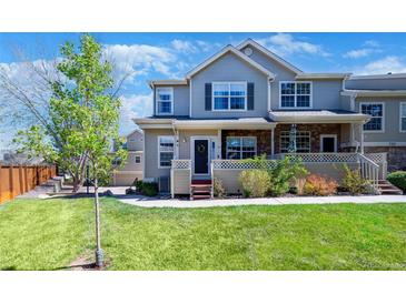 Charming two-story townhome with a well-manicured lawn and inviting front porch, creating a warm curb appeal at 230 W Jamison Cir # 31, Littleton, CO 80120