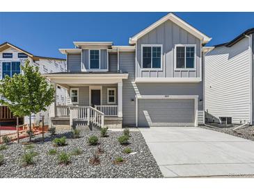 Charming two-story home featuring a stylish gray exterior, landscaped yard, and an attached two-car garage at 305 Welded Tuff Trl, Castle Rock, CO 80104