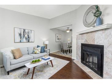 Inviting living room with a fireplace and an open view to the dining area for seamless entertaining at 8260 Washington St # 78, Denver, CO 80229