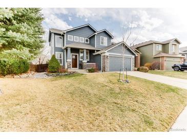 Charming two-story blue home with a well-manicured lawn and attached gray two-car garage at 10882 Bullock Ct, Parker, CO 80134