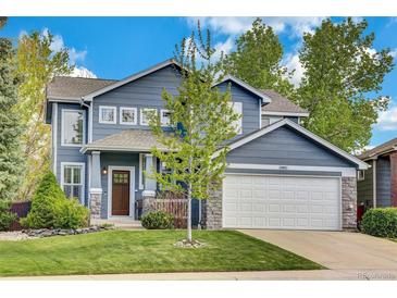 Charming two-story home featuring a blue exterior, stone accents, and a well-manicured lawn at 10882 Bullock Ct, Parker, CO 80134