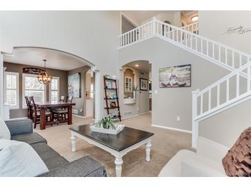 Inviting living room with an open layout leading to dining and staircase, perfect for entertaining at 10882 Bullock Ct, Parker, CO 80134