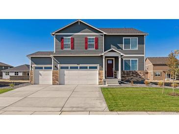 Charming two-story home featuring a three-car garage and well-manicured lawn at 1884 Westport Ave, Berthoud, CO 80513