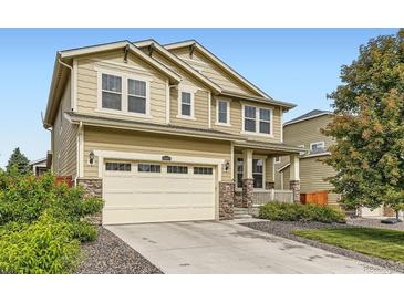 Inviting two-story home with a manicured lawn, charming front porch, and attached two-car garage at 14067 Hudson St, Thornton, CO 80602