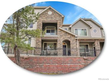 Beautiful multi-level home with stone accents, balconies, and well-maintained landscaping at 9085 E Phillips Dr, Centennial, CO 80112