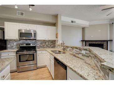 Bright kitchen features stainless appliances, white cabinets, granite counters, and stylish backsplash at 2182 Eagle Ave, Superior, CO 80027