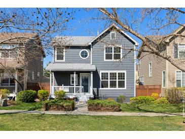 Charming two-story home with gray siding, white trim, front porch, and well-manicured landscaping at 1913 Julian St, Denver, CO 80204