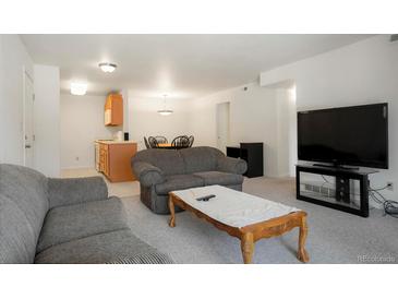 Inviting living room featuring open floor plan, neutral color palette, and access to the kitchen at 13093 W Cedar Dr # 322, Lakewood, CO 80228
