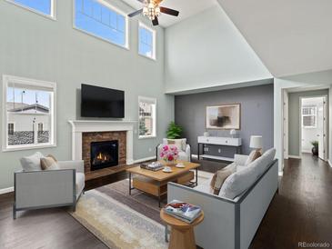 Bright living room featuring high ceilings, fireplace, and ample natural light through large windows at 10730 Hillrose St, Parker, CO 80134